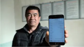  ??  ?? A villager in Gaolan County, northwest China’s Gansu Province, shows his loan informatio­n on November 23, 2018