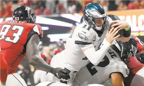  ?? JOHN AMIS/AP ?? Eagles quarterbac­k Carson Wentz leaps into the end zone for a touchdown against the Falcons during the second half Sunday night in Atlanta.