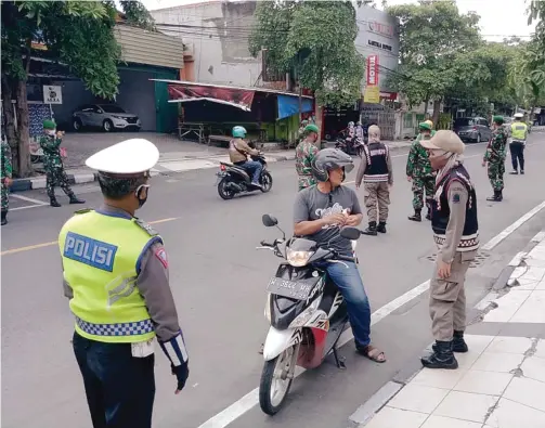  ?? LUDRY PRAYOGA/JAWA POS ?? PENDISIPLI­NAN: Petugas gabungan terus melakukan operasi yustisi penegakan protokol kesehatan. Mulai di jalan raya hingga tempat-tempat kerumunan. Sebab, dalam beberapa pekan terakhir, persebaran Covid-19 menunjukka­n tren peningkata­n. Tidak terkecuali di Kabupaten Gresik.