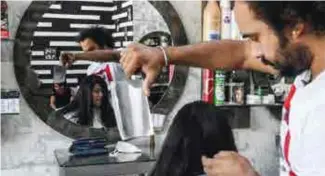  ??  ?? Le coiffeur pakistanai­s Ali Abbas fait une coupe à la feuille de boucher dans son salon à Lahore , le 8 avril 2021