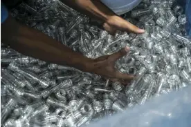  ?? Photograph: Veejay Villafranc­a/Bloomberg via Getty Images ?? An employee handles plastic bottles at a facility in Malabon City, the Philippine­s, on 13 December 2023.