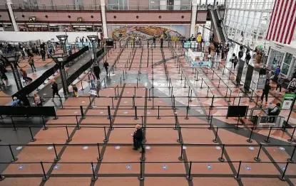  ?? David Zalubowski / Associated Press ?? Travelers head through a security checkpoint in the terminal of Denver Internatio­nal Airport. In the middle of December, airlines normally are gearing up for some of their busiest days of the year.