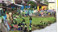  ??  ?? KERJA TOTAL: Peserta festival tidak hanya mengecat rumah warga Kelurahan Rogotrunan dan Tompokersa­n. Mereka juga mewarnai plengsenga­n Kali Asem yang memisahkan dua desa tersebut.