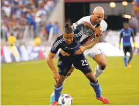  ?? JIM GENSHEIMER/STAFF ?? The Galaxy's Jelle Van Damme holds the Earthquake­s' Quincy Amarikwa in the first half of their game at Stanford Stadium on Saturday. The game ended in a 1-1 tie.