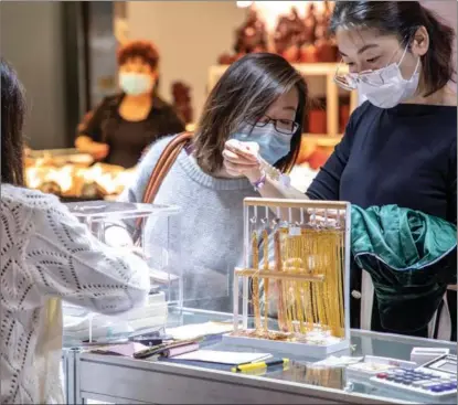  ?? PROVIDED TO CHINA DAILY ?? Customers choose gold jewelry at the Shanghai World Jewelry Expo in October.