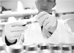  ??  ?? This file photo taken on Dec 15, 2015 shows a technician holding blood samples about to be tested at the French national anti-doping laboratory, in Chatenay-Malabry, outside Paris. — AFP photo