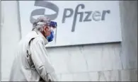  ?? (AFP) ?? (File photo) A man wearing facemask and shield walks past the Pfizer headquarte­rs in New York.