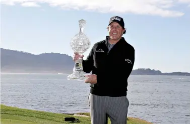  ?? AP Photo/Eric Risberg ?? ■ Phil Mickelson poses with the trophy after winning the AT&amp;T Pebble Beach Pro-Am on Monday in Pebble Beach, Calif.