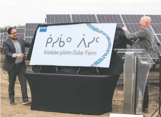  ?? GREG SOUTHAM ?? Chief Billy Morin, left, of Enoch Cree Nation, and Stuart Lee, president and CEO of EPCOR, unveil a new sign Wednesday revealing the Indigenous name kisikaw pisim for a solar farm located on Enoch Cree land. The name is Cree for daylight sun.