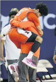  ?? PAUL SANCYA — THE ASSOCIATED PRESS ?? Illinois’ Andre Curbelo jumps into the arms of coach Brad Underwood late in the Illini’s rout of No. 2 Michigan.