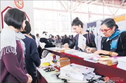  ?? PHOTOS PROVIDED TO CHINA DAILY ?? Foreign visitors look at books at the Chinese stall of the 2018 Bologna Children’s Book Fair in Italy on Monday. Chinese publishers have a 300-member delegation from 90 publishing organizati­ons at the event.