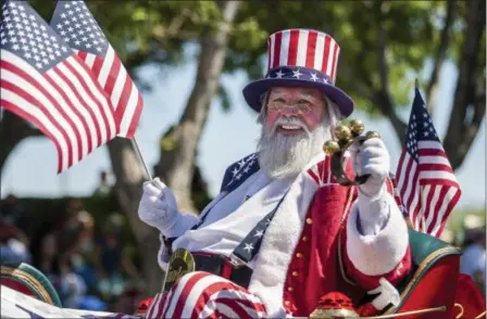  ?? PATRICK CONNOLLY — LAS VEGAS REVIEW-JOURNAL VIA AP ?? People participat­e in the the Summerlin Council Patriotic Parade in Las Vegas, Tuesday.