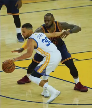  ??  ?? Golden State Warriors guard Stephen Curry (30) battles for the ball with Cleveland Cavaliers forward LeBron James (23) in the first half of the NBA Finals at Oracle Arena. (USA TODAY Sports)