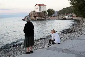  ??  ?? Nice and quiet: Villagers enjoying the evening breeze at the village of Skala Sikaminias. — AP