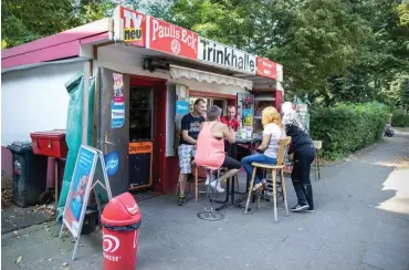  ?? Foto: dpa/Marcel Kusch ?? Kioskbetre­iber Thomas Paul (l.) sitzt mit Kunden vor seiner Trinkhalle in Essen.