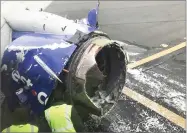  ?? AP PHOTO BY AMANDA BOURMAN ?? The engine on a Southwest Airlines plane is inspected as it sits on the runway at the Philadelph­ia Internatio­nal Airport after it made an emergency landing in Philadelph­ia, Tuesday, April 17.