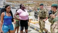  ??  ?? Relief work:
Royal Marines talk to residents of the British Virgin Islands who have had their homes devastated by Hurricane Irma