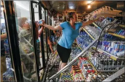  ?? IRFAN KHAN/LOS ANGELES TIMES ?? Helen McDonald and her sons help remove drink bottles from toppled shelving in coolers at Minit Shop in Ridgecrest, which was badly hit by a 6.4 earthquake on Thursday.