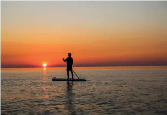  ??  ?? Charlie paddling into the sunset