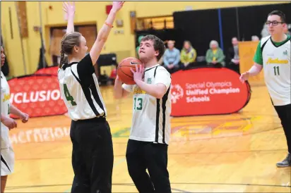  ??  ?? Above, Caleb Harlow (13) gets off a shot during a “March Madness Unified Hoops Rally,” celebratin­g North Smithfield High School as a Special Olympics Unified Champion Schools, one of three in the state. Also taking part, are, from left, Tyler Hall,...