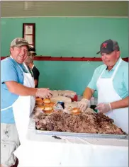  ?? Donnis Hueftle-Bullock ?? Todd Fenton of Broken Bow and Brian Miller of Callaway make sandwiches at the 2017 Free Pit BBQ. Each year the Free Pit BBQ feeds thousands of people at the fair.