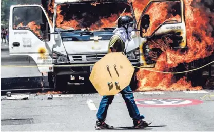  ?? AFP ?? Varios manifestan­tes incendiaro­n un camión, este martes, para bloquear una calle en Caracas, durante una protesta opositora contra el gobierno de Nicolás Maduro.