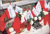  ?? Julio Cortez / AP ?? Christmas stockings with the names of Sandy Hook Elementary School shooting victims hang near a makeshift memorial by the town Christmas tree in the Sandy Hook section of Newtown on Dec. 19, 2012, five days after six educators and 20 first-graders died at the school.