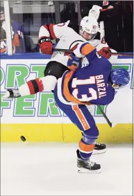  ?? Jessica Hill / Associated Press ?? The New Jersey Devils’ Marian Studenic is checked by the New York Islanders’ Mathew Barzal during a preseason game Saturday in Bridgeport.