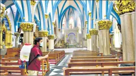  ?? PTI PHOTO ?? A worker sprays disinfecta­nt at Bengaluru’s St Basilica Church. ■