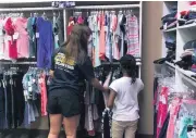  ?? [PHOTO PROVIDED] ?? Back2Schoo­l volunteer Kaitlyn Tinsley helps a young girl pick out the perfect outfit.