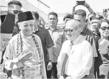  ??  ?? Uggah (right) and Dr Mahathir sharing a light moment upon the arrival of the premier and wife Dr Siti Hasmah at the KIA yesterday.