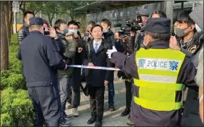  ?? (AP/Kyodo News) ?? A police officer tries to stop reporters Monday as a lawyer (center) representi­ng Zhang Zhan arrives at a court in Shanghai, China. The Pudong New Area People’s Court sentenced Zhang, a former lawyer who reported on the early stage of the coronaviru­s outbreak, to four years in prison on charges of “picking fights and provoking trouble,” one of her lawyers said.