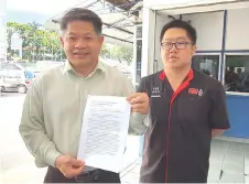  ??  ?? Dr Ting holding his press release outside Miri Central Police Station yesterday. At right is Democratic Action Party (DAP) Miri Youth chief Peter Hee.