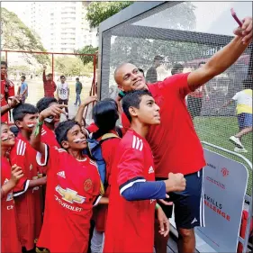  ?? REUTERS ?? Former Manchester United football player Wes Brown clicks a selfie with schoolchil­dren during a promotiona­l event in Bengaluru, on Friday.