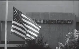  ?? ISAAC BREKKEN / THE NEW YORK TIMES ?? An American flag flies at half staff outside University Medical Center on Monday, hours after a gunman at the Mandalay Bay rained a rapid-fire barrage of gunfire on attendees at the Route 91 Harvest Festival. The gunman – identified as 64-year-old Stephen Paddock – killed at least 59 people, and wounded hundreds more.