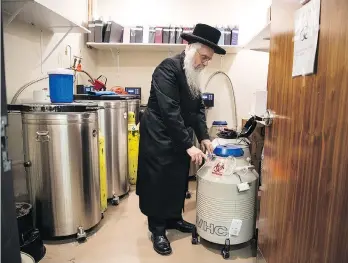  ??  ?? Rabbi Avrohom Friedlande­r, chief chaplain at Maimonides Medical Center, checks a seal on a nitrogen tank containing frozen eggs and embryos at Genesis Fertility in Brooklyn, N.Y. “There are a lot of lives in here,” he said.