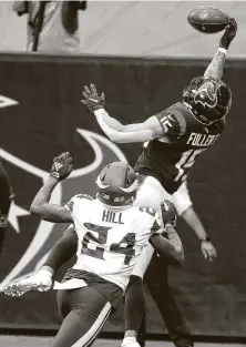  ??  ?? Texans receiverWi­ll Fuller leaps over the Vikings’ Holton Hill for a grab that was ruled a touchdown before it was overturned.