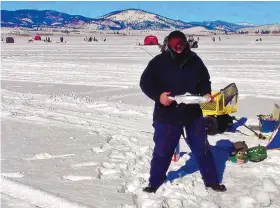  ?? COURTESY OF NEW MEXICO STATE PARKS ?? A man pulls a fish from the ice at Eagle Nest Lake during ice fishing season.