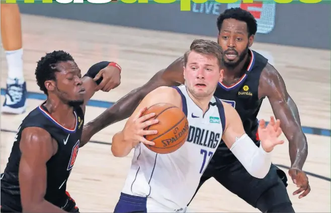  ??  ?? Doncic, defendido por Jackson y Green, de los Clippers, durante el segundo partido de la primera ronda de playoffs, en Florida.