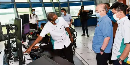  ??  ?? Operating system: Dr Wee and Chong (right) being briefed on Westports’ vessel traffic management system.