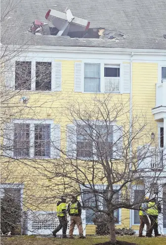  ?? STAFF PHOTO BY PATRICK WHITTEMORE ?? DEADLY SCENE: An airplane sticks out of a building in a condo complex in Methuen. Residents have warned the nearby airport about close calls over their homes.