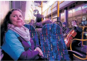  ?? FOTOS: KRÄMER ?? Im Bus der Linie R10 spielt der unterwegs zugestiege­ne Cellist Julien Blondel. Links vorn lauscht Opernsänge­rin Elizabeth Wiles, die hier als Zuhörerin mit von der Partie ist.