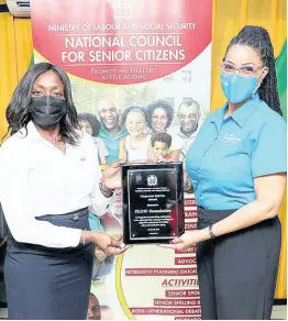  ?? ?? Kayon Mitchell (right), executive director, FLOW Foundation, accepts the Corporate Service Award from Casandra Morrison, executive director, National Council for Senior Citizens.