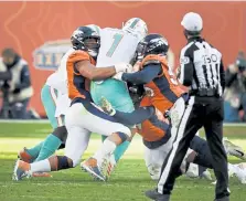  ?? Andy Cross, The Denver Post ?? From left, Denver‘ s DeMarcus Walker, Malik Reed and Bradley Chubb sack Miami quarterbac­k Tua Tagovailoa in the second quarter at Empower Field at Mile High on Sunday.