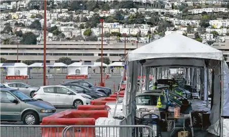  ?? Jeff Chiu / Associated Press ?? Health care workers administer doses of the COVID-19 vaccine at a drive-thru location in San Francisco on Monday.