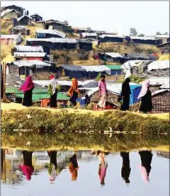  ?? MUNIR UZ ZAMAN/AFP ?? Rohingya refugees walk back to their homes at Balukhali refugee camp in the Bangladesh­i district of Ukhia on November 22.