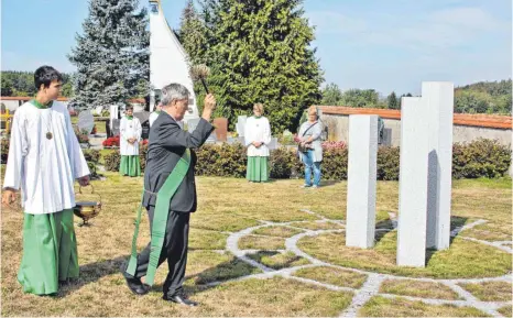  ?? FOTO: ARTUR K. M. BAY ?? Diakon Johannes Jann segnet den neuen Bereich auf dem Friedhof in Renhardswe­iler.