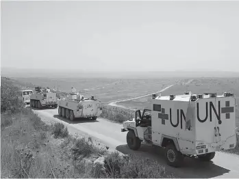  ??  ?? Irish members of the United Nations Disengagem­ent Observer Force convoy manoeuvre near the border of Syrian territory, close to the town of Buqaata in the Israeli- annexed Golan Heights on Sunday.