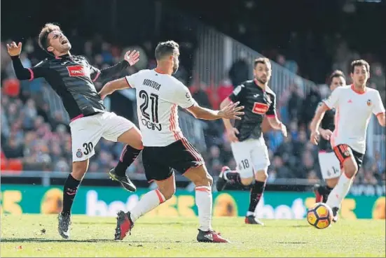  ?? MIGUEL ÁNGEL POLO / EFE ?? El valenciani­sta Montoya atura sense contemplac­ions Melendo, a qui Sánchez Flores va recórrer en el segon temps