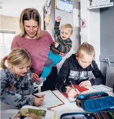  ?? MICHAEL PROBST/AP ?? Katja Heimann helps two of her children with their studies in their home in Eisemroth, Germany.